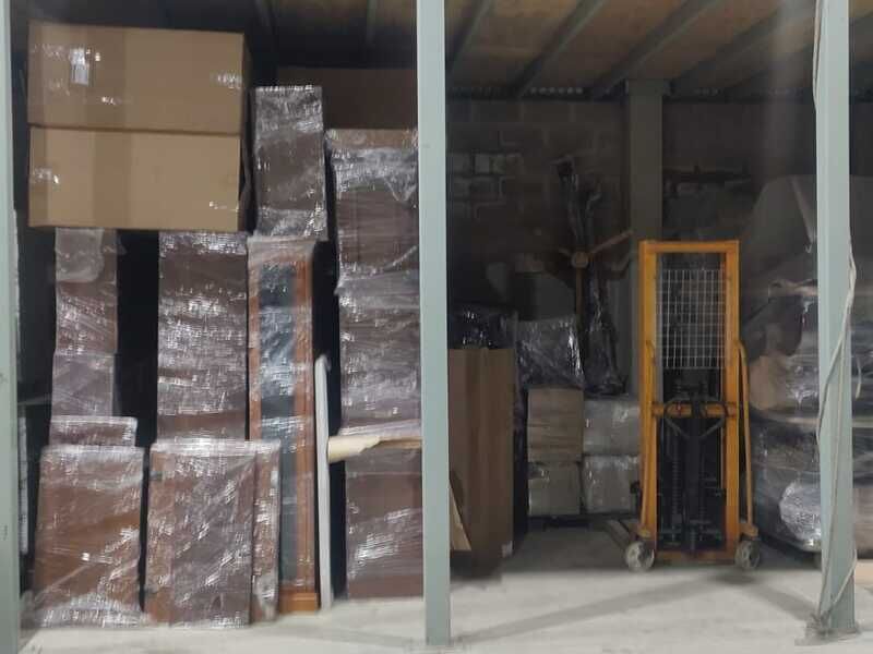 Muebles y cajas embalados en film bajo el entrepiso del guardamuebles